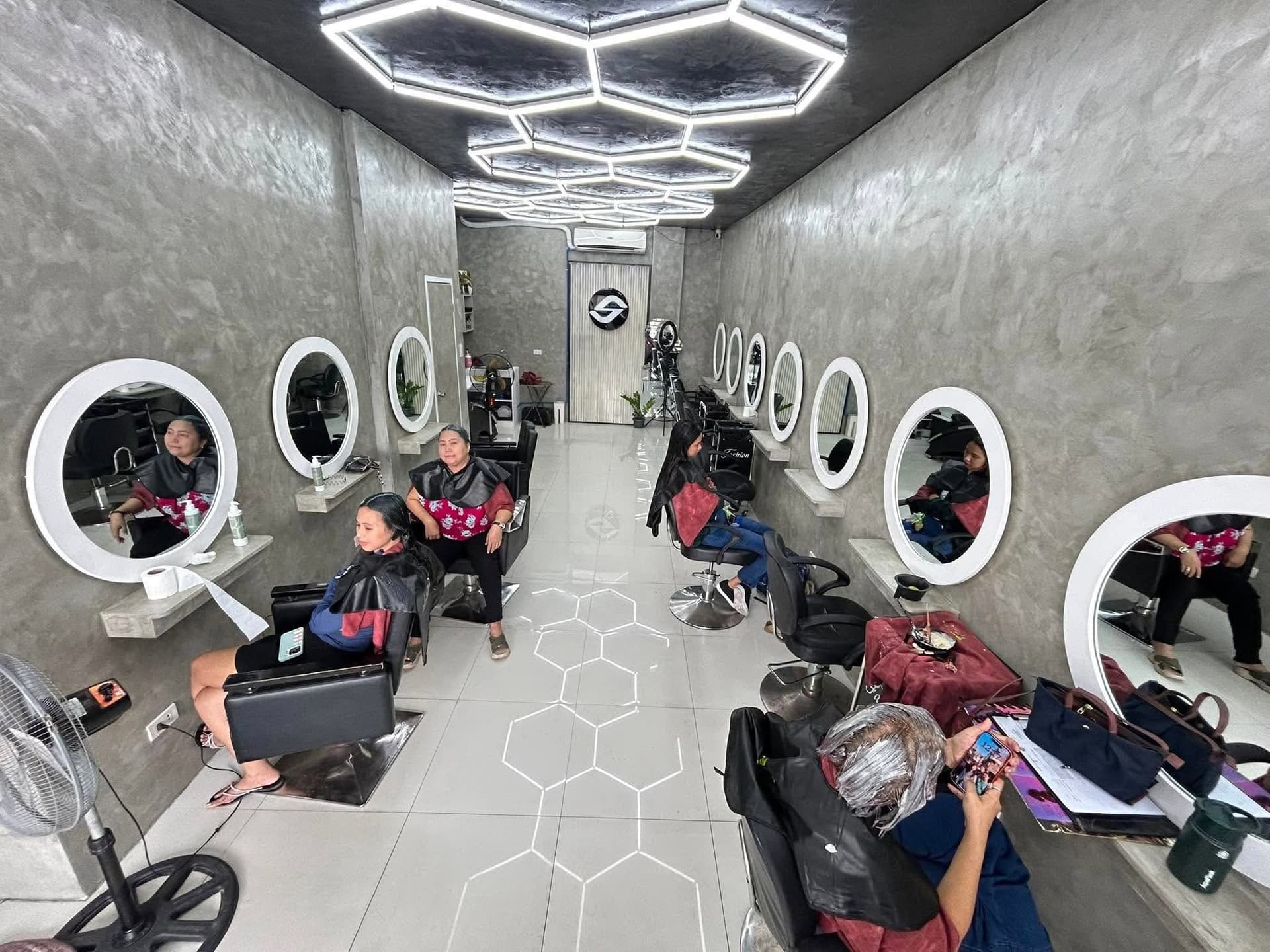 SandreaLee salon interior with round mirrors and hexagon ceiling lights